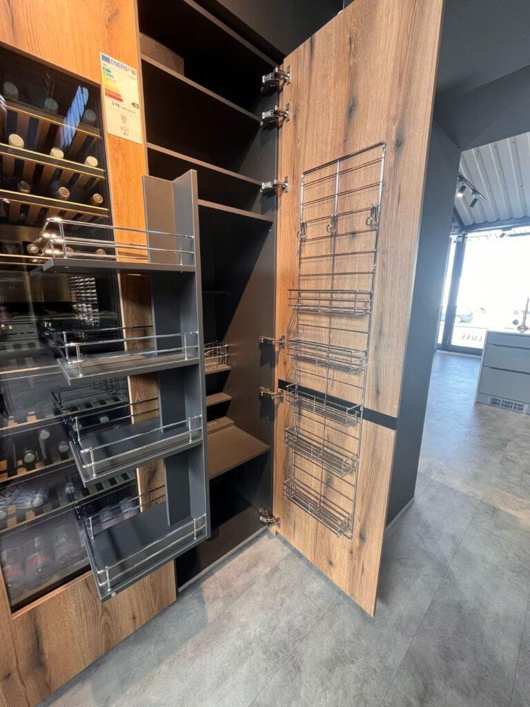 Moderner Küchenschrank mit offenen Regalen, ausziehbaren Körben und integriertem Weinkühlschrank.
