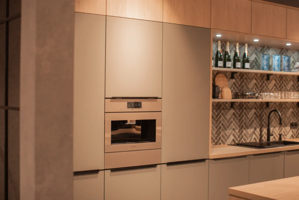 Moderne Küche mit neutralen Tönen, Einbaugeräten, Spülbecken und offenen Regalen.