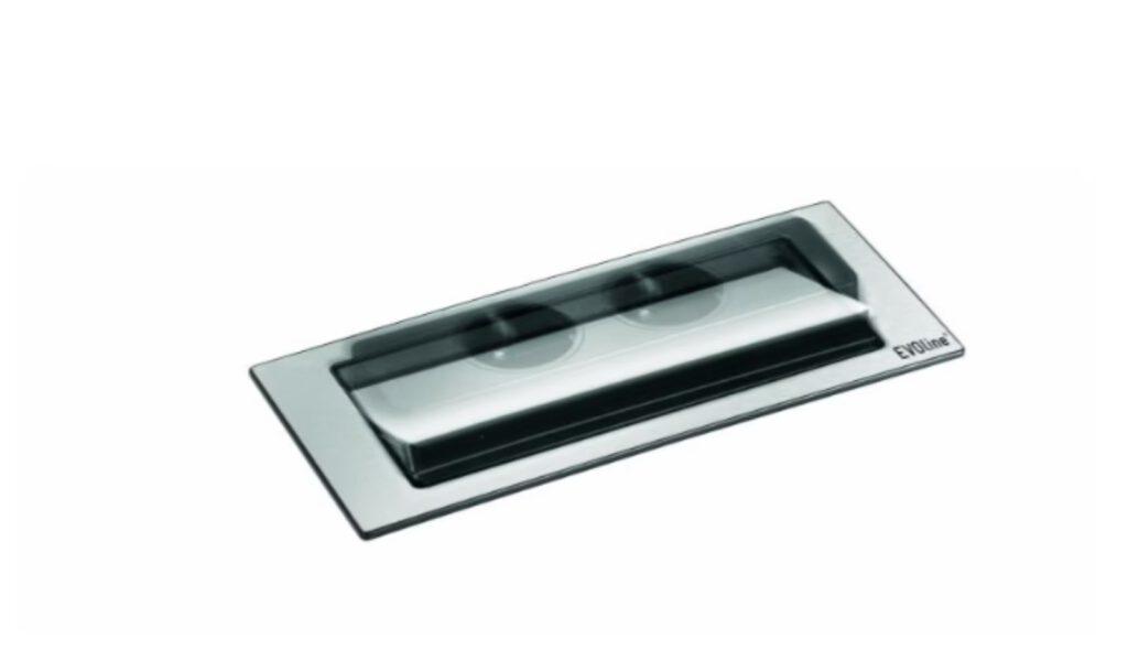 Eine silberne, versenkbare Steckdosenleiste mit "EVOline"-Schriftzug in einer Oberfläche eingelassen.