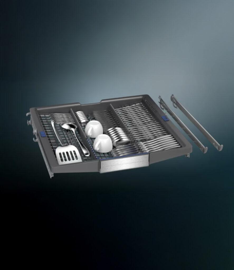 Geöffnete Geschirrspülmaschine mit Besteckschublade, gefüllt mit Besteck und zwei weißen Kaffeetassen.