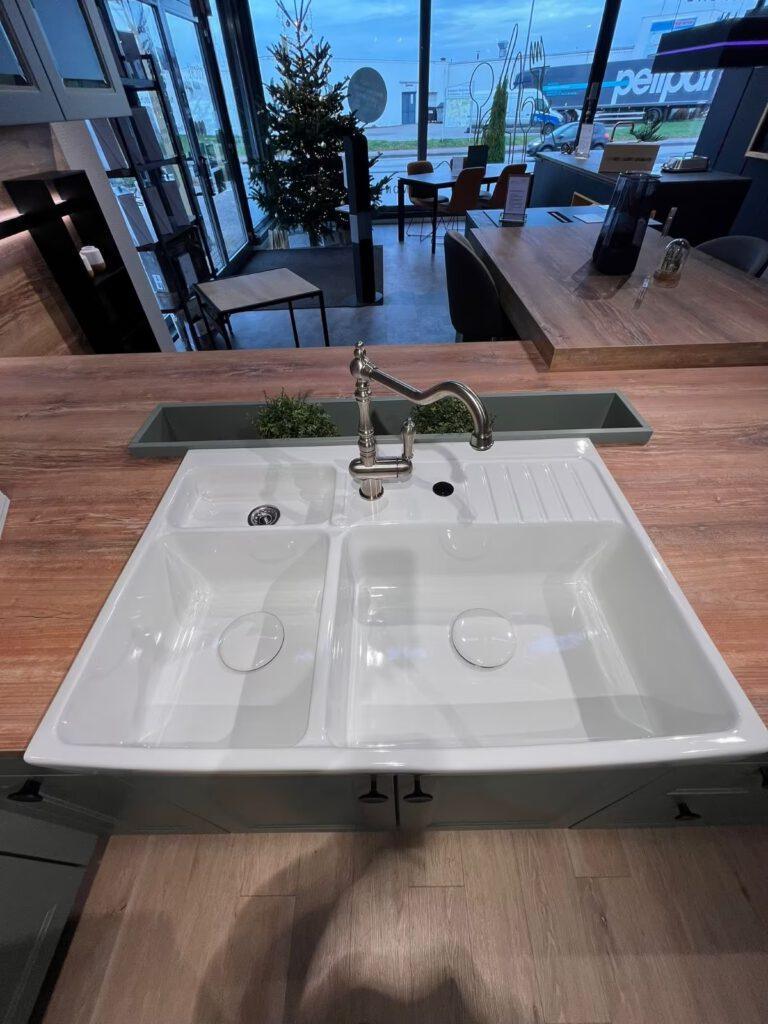 Moderne Küche mit Doppelspülbecken, gebogenem Wasserhahn und Holzarbeitsplatte, weihnachtlich dekoriert.