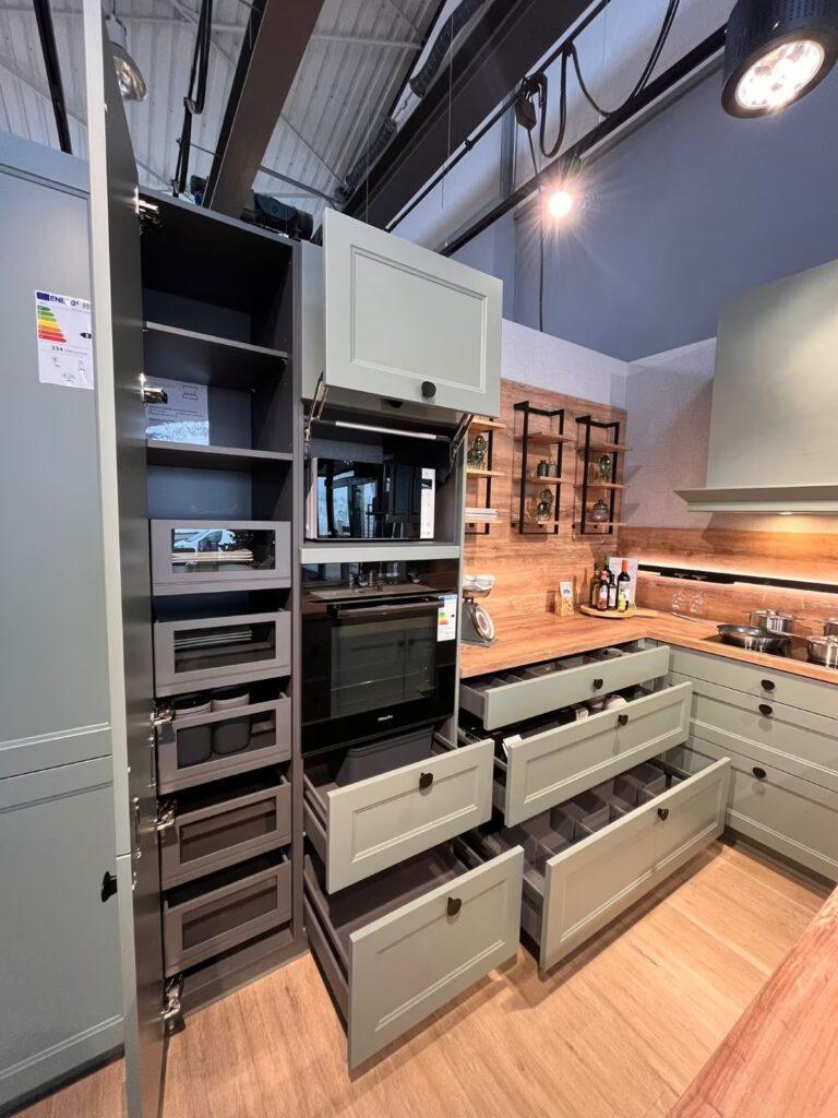 Moderne Küche mit offenen Schränken, Holzarbeitsplatte und eingebautem Ofen in hellen Grautönen.