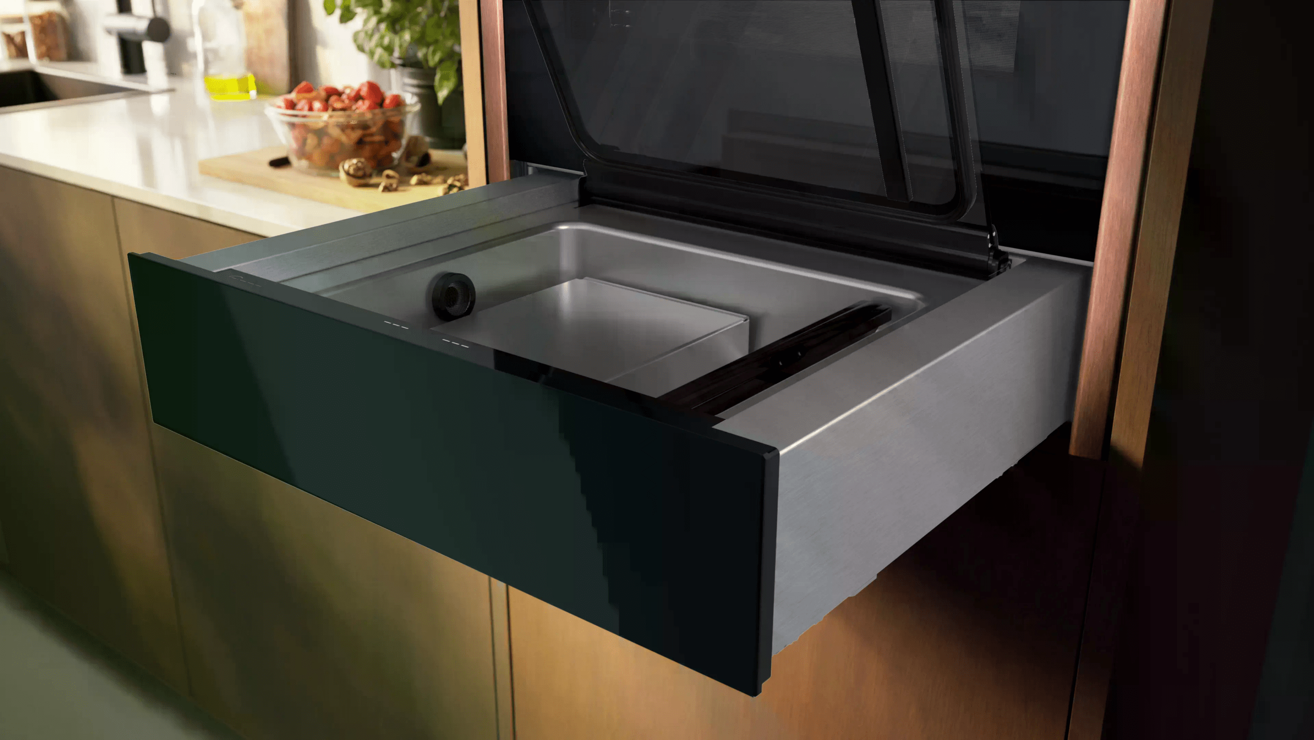 Moderne Küche mit offenem Vakuumiergerät, Erdbeeren und Ölflasche auf der Arbeitsplatte.