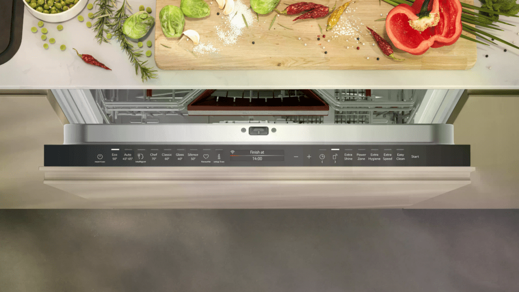 Moderne Küche mit frischen Zutaten auf einem Schneidebrett und offenem Geschirrspüler voller Geschirr.