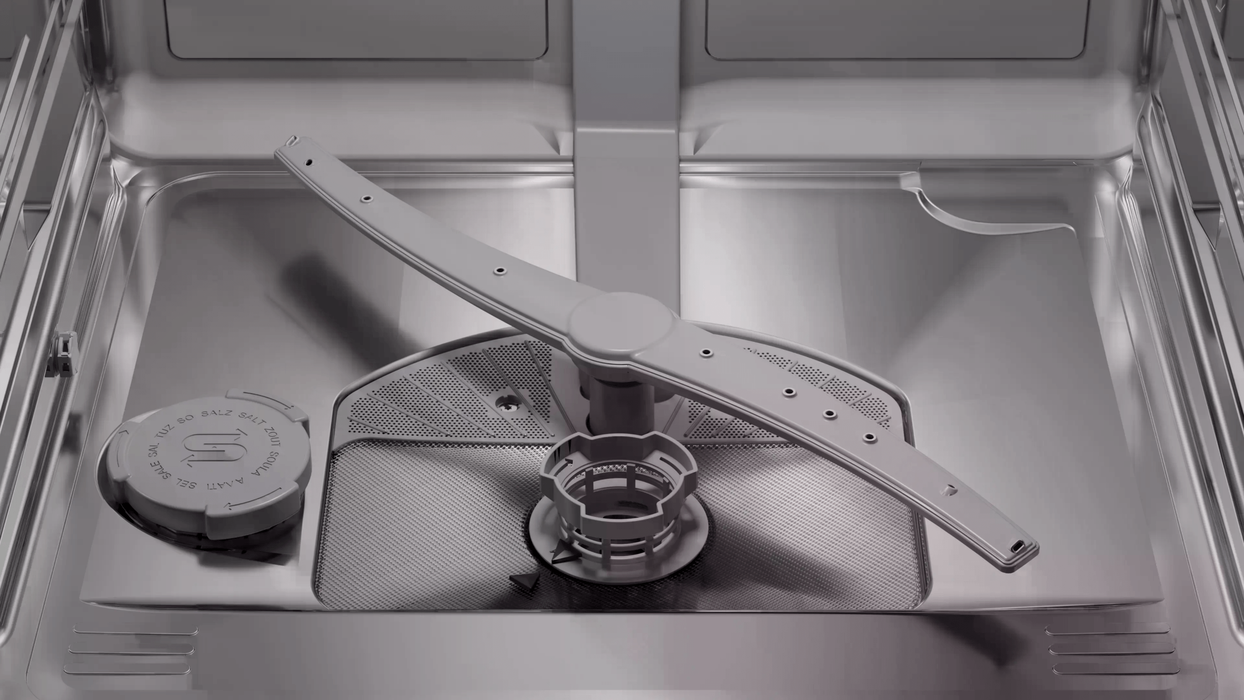Das Innere einer Geschirrspülmaschine zeigt einen Sprüharm, ein Sieb und einen Salzfachdeckel.