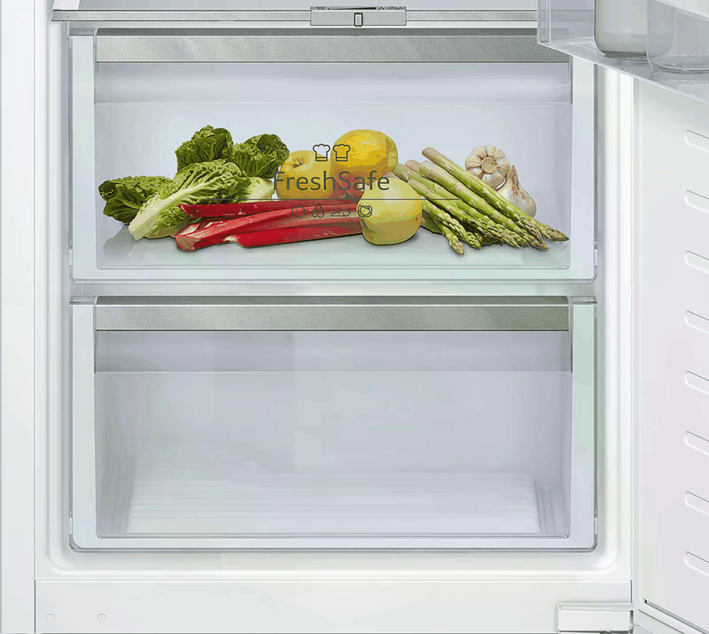 Ein Kühlschrank zeigt frisches Gemüse und Obst in einer klaren Schublade, darunter Salat und Paprika.