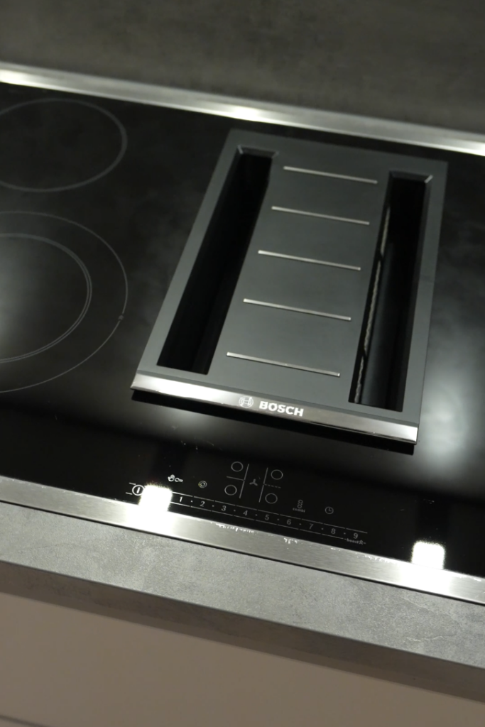 Modernes Bosch-Induktionskochfeld mit integriertem Dunstabzug, glänzend schwarz und funktional.