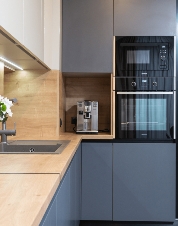 6 Moderne, minimalistische Küche mit Holzarbeitsplatte, Edelstahlgeräten und grauen Schränken.