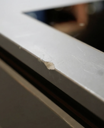 Nahaufnahme einer Küchenarbeitsplatte mit einer beschädigten, abgesplitterten Kante.