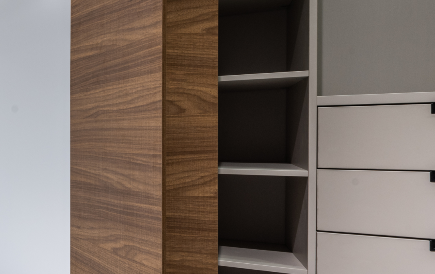 Moderner Innenraum mit offenem Schrank, Holzpaneel und hellem Marmorboden, minimalistisch gestaltet.